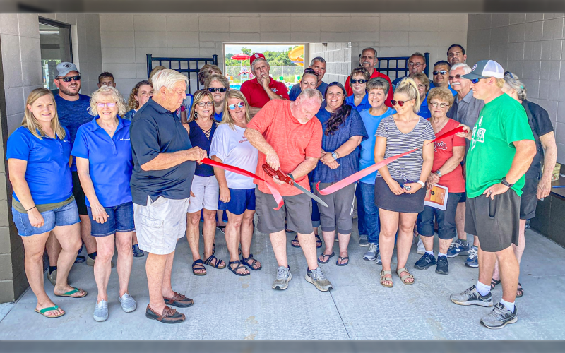 PHIL McKERNAN, Park Board President, cuts the ribbon to officially open the new pool.