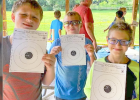 Some sharp shooters from the pack. They are proudly displaying hole-ridden targets, and their smiles say it all.