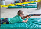 A camper takes aim at the target ahead.